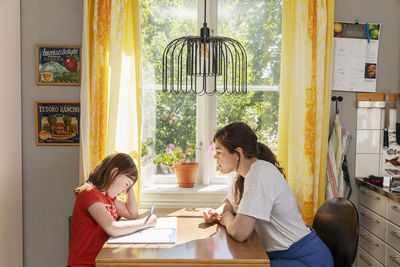 Mother helping daughter with homework