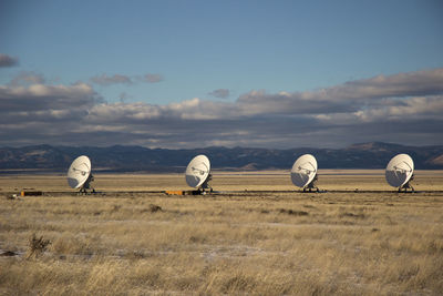 Antennas on field against sky