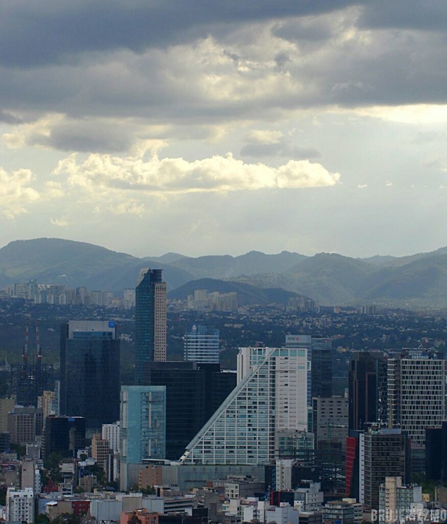 building exterior, architecture, city, built structure, cityscape, sky, mountain, cloud - sky, skyscraper, mountain range, residential district, residential building, crowded, high angle view, cloud, cloudy, office building, city life, tall - high, residential structure