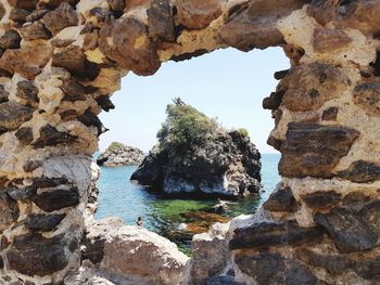 Rock formations by sea against sky