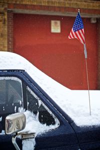 Red umbrella on snow covered car