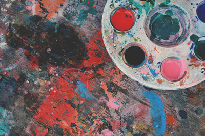 High angle view of colorful palette on stained wooden table