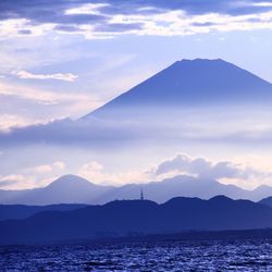 Scenic view of sea and mountains against sky