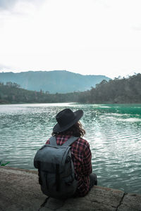 Man looking at lake against mountain range