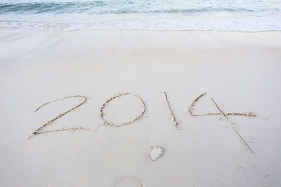 High angle view of text on sand at beach