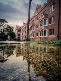 Reflection of building in puddle on canal