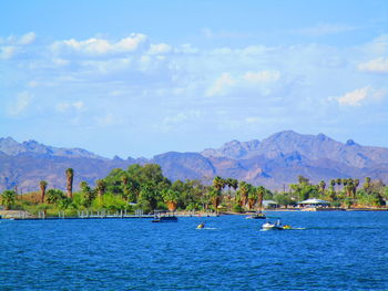 Scenic view of sea and mountains against sky