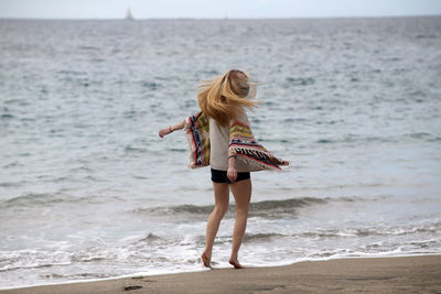 Full length of woman standing on beach