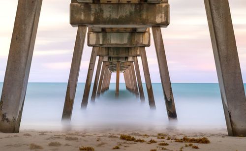 View of pier on beach against sky