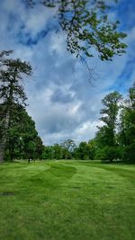 Scenic view of grassy field against cloudy sky