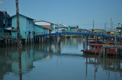 View of fishing boats moored in lake against sky