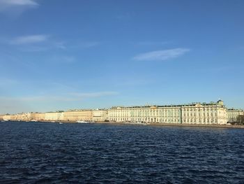 View of building by sea against blue sky