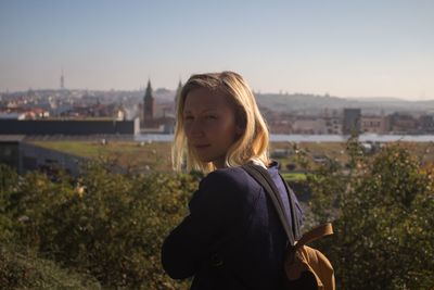 Portrait of young woman against clear sky