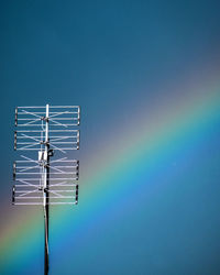 Low angle view of electrical equipment against clear blue sky