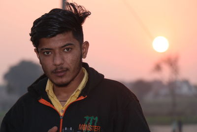 Portrait of young man against sky during sunset