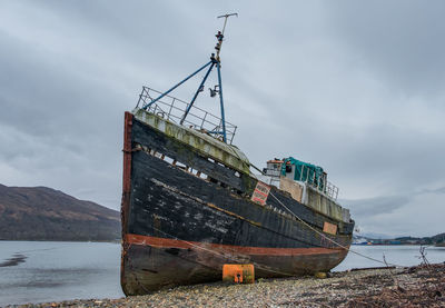 Abandoned boat moored at lake