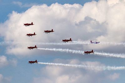 Low angle view of fighter planes flying against sky