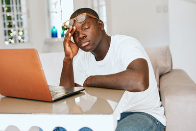 Young man using mobile phone at home