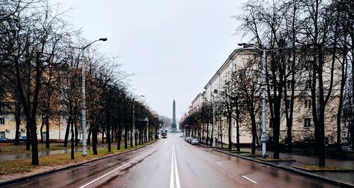 Road amidst trees against clear sky