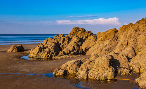 Scenic view of rocks on beach against sky