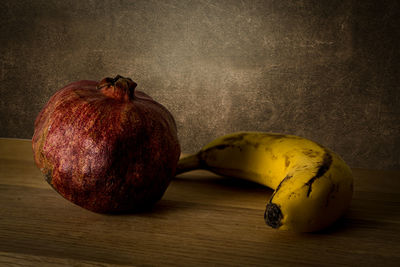 Close-up of fruits on table against wall