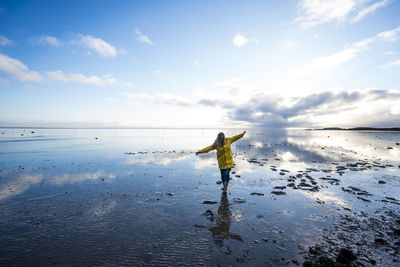 Pretty woman poses in the middle of the reflected sea.