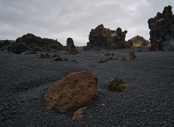 Rock formations on beach against sky