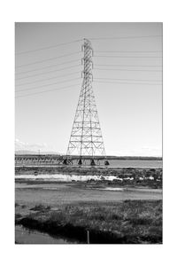 Electricity pylon on field against clear sky