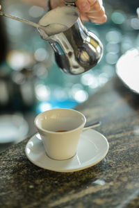 Hands of young adult caucasian female barista at work preparing