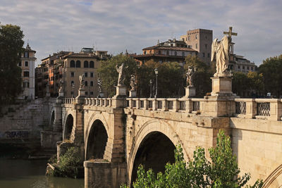 Arch bridge in city against sky