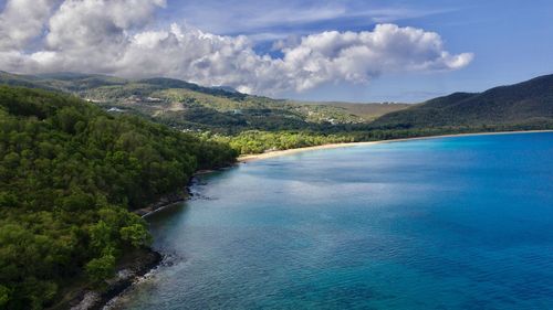 Scenic view of sea and mountains against sky