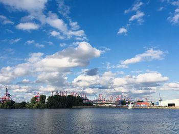 Scenic view of river by buildings against sky