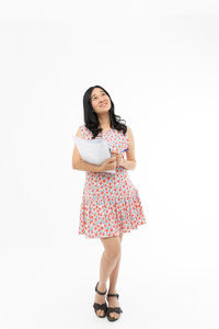 Portrait of woman standing against white background