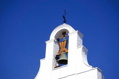 Low angle view of clock tower against clear blue sky