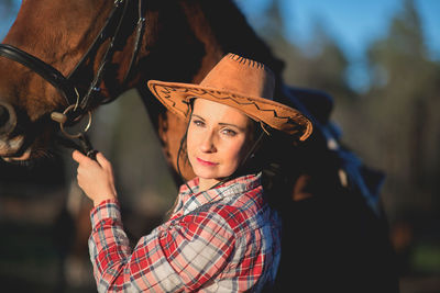 Portrait of woman by horse at ranch