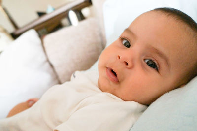 Portrait of baby lying on bed at home