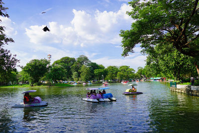 People floating on river against sky