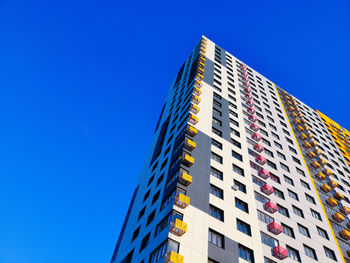 Low angle view of modern building against blue sky