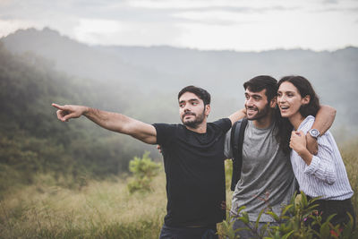 Young couple standing on smart phone against sky