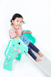 Portrait of boy playing with toy against white background