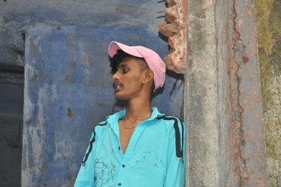 Portrait of man standing against wall