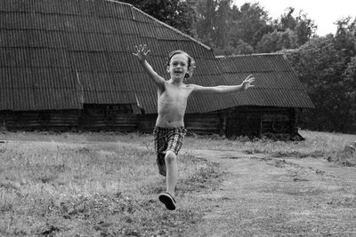 Full length of shirtless boy, running in rain