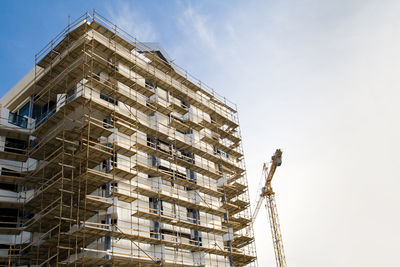 Low angle view of building under construction against sky