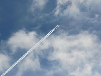 Low angle view of vapor trail against blue sky