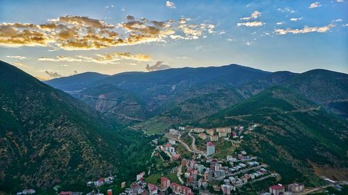 Aerial view of townscape and mountains against sky