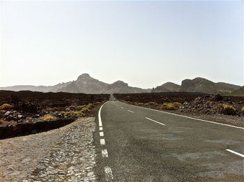 Empty road leading towards mountains