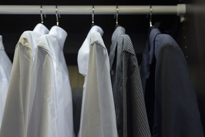 White clothes hanging on rack in store