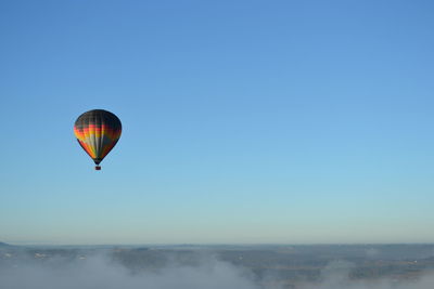 Hot air balloon flying against clear blue sky