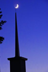 Low angle view of illuminated building against blue sky