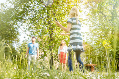 Rear view of people against plants